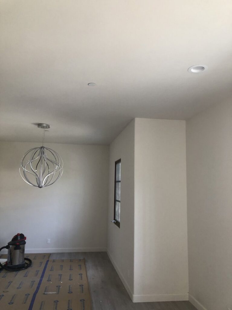 A room with a decorative light fixture and recessed lighting installed by CLB Electric Corporation in Norwalk, CA