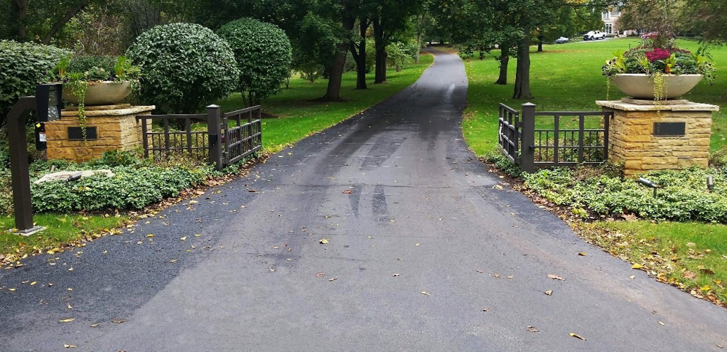 Decorative metal driveway gates with stone pillars installed by Gate Options in West Chicago, IL