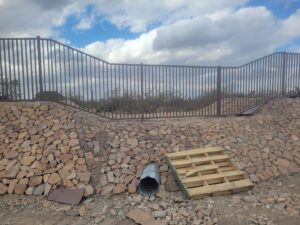 A decorative metal fence installed atop a natural rock wall by SFA Contracting LLC in Tucson, AZ.
