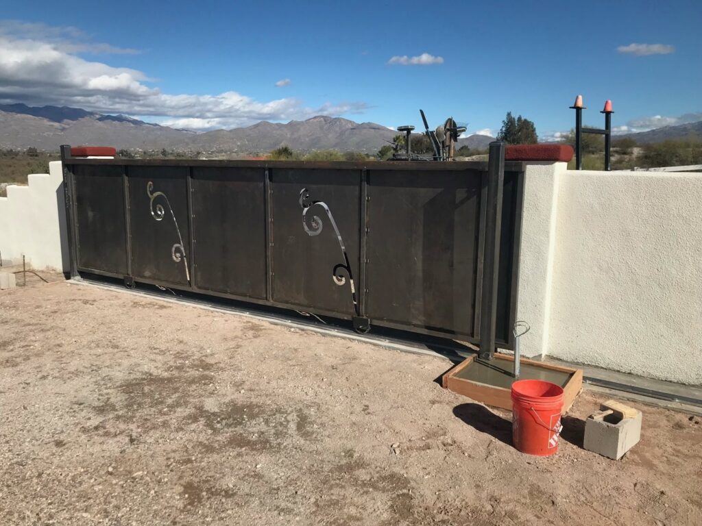 A custom decorative metal sliding gate installed by SFA Contracting LLC, a professional fencing contractor in Tucson, AZ.