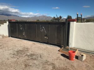 A custom decorative metal sliding gate installed by SFA Contracting LLC, a professional fencing contractor in Tucson, AZ.