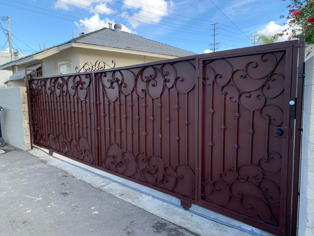 A long, decorative brown metal sliding gate, a project completed by Portugal's IronWorks in Los Angeles, CA.