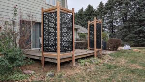 Two decorative privacy screens with geometric patterns on a deck installed by Babb Custom Fence in Sioux Falls, SD.