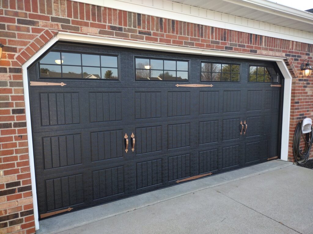 A stylish residential garage door with windows and decorative hardware installed by Honest Overhead Garage Doors in Elizabethtown, KY.