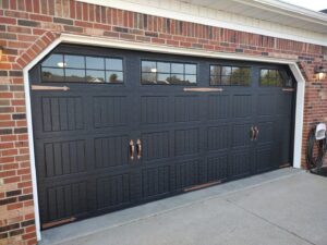 A stylish residential garage door with windows and decorative hardware installed by Honest Overhead Garage Doors in Elizabethtown, KY.