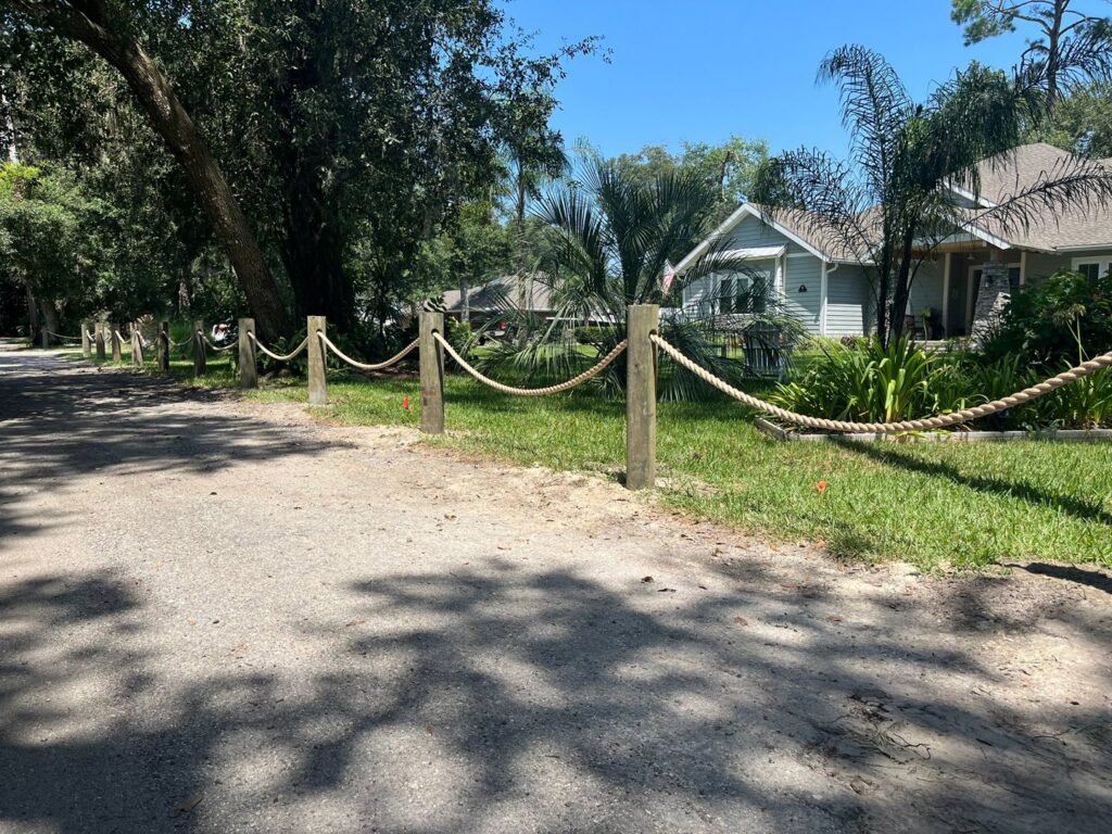 A decorative rope fence with sturdy wooden posts, adding a rustic touch to a property by Exacta FENCE LLC in Jacksonville, FL.