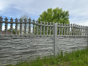 A decorative stacked stone concrete fence with ornate top elements by StackWall Manufacturing in Pomona, CA.