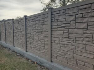 A decorative stone-look fence with a concrete base installed by 5-Alarm Fence Company in New Orleans, LA.