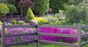 A decorative two-rail fence installed in a vibrant garden by Global Supply in Lindon, UT.