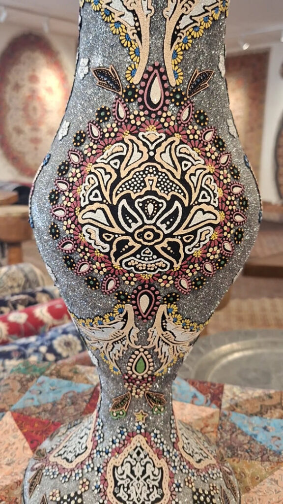 A decorative vase with traditional Persian rugs visible in the background at Art Of Persia in Portland, OR.