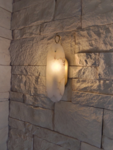 A decorative wall sconce light fixture installed on a stone wall by Ryco Electric in York, PA