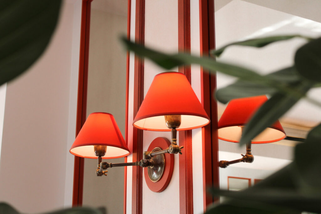 Decorative wall sconces with red shades installed in an interior space by ACJ Electric LLC in North Babylon, NY.