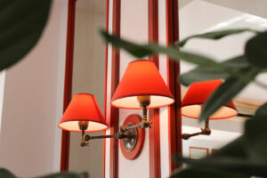 Decorative wall sconces with red shades installed in an interior space by ACJ Electric LLC in North Babylon, NY.