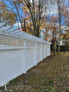 A long section of decorative white privacy fence with lattice work, installed by Teto's Fence Installation in Bridgeport, CT.
