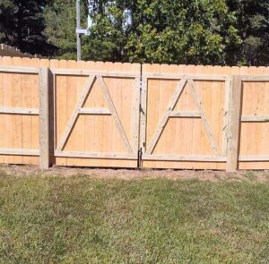 A decorative wood double gate with an 'A' pattern, expertly installed by Aguilarfence services LLC in Clayton, NC.