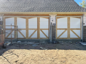 Decorative wood and white panel garage doors under construction by L & S Overhead Door in Tulsa, OK.