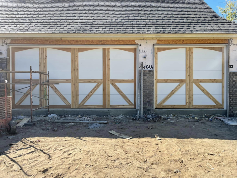 Decorative wood and white panel garage doors under construction by L & S Overhead Door in Tulsa, OK.