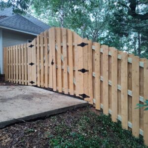 A decorative wood picket fence with an arched gate and black hardware, installed by The Fence Dudes in Birmingham, AL.