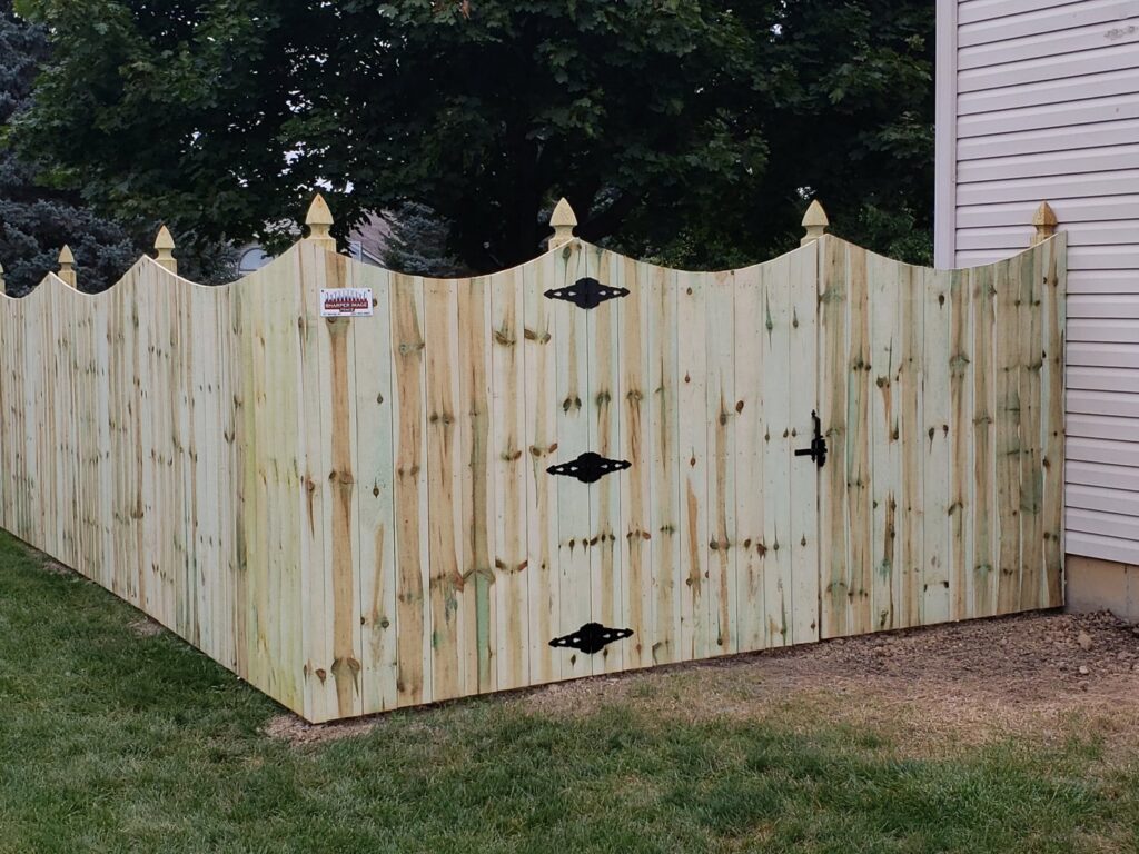 A newly installed decorative wood privacy fence with a gate by Sharper Image Fence in Fort Wayne, IN.