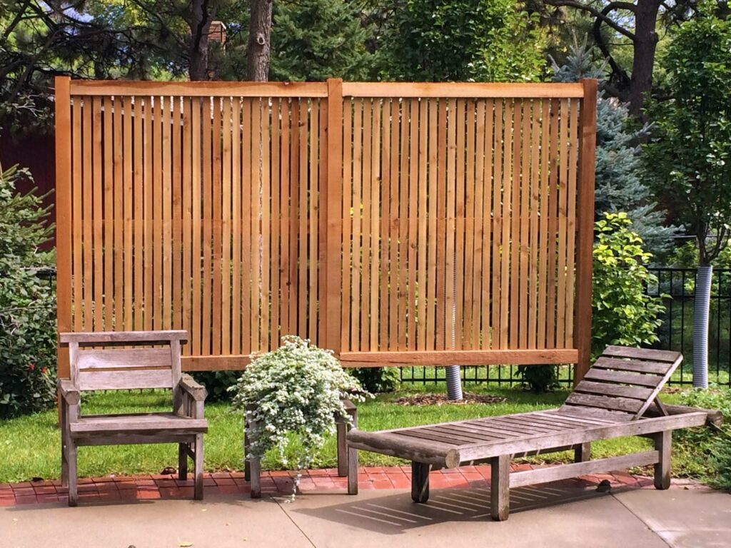 A decorative wood privacy screen installed in a backyard by American Fence Company - Omaha in Omaha, NE.