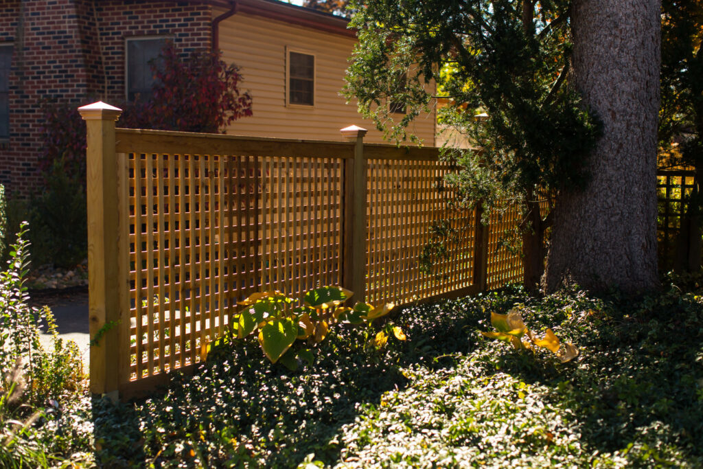 A decorative wooden lattice fence providing privacy in a garden setting by Integrous in Gap, PA
