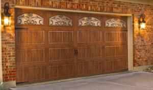 A beautiful decorative wooden-look garage door with windows and wrought iron accents, installed by Johns Garage Doors in Tucson, AZ.
