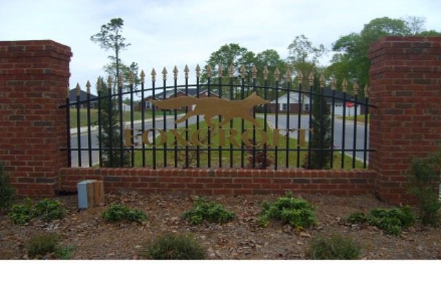 A decorative wrought iron entrance gate with brick pillars for a community by Sumter Fence Company in South Sumter, SC.
