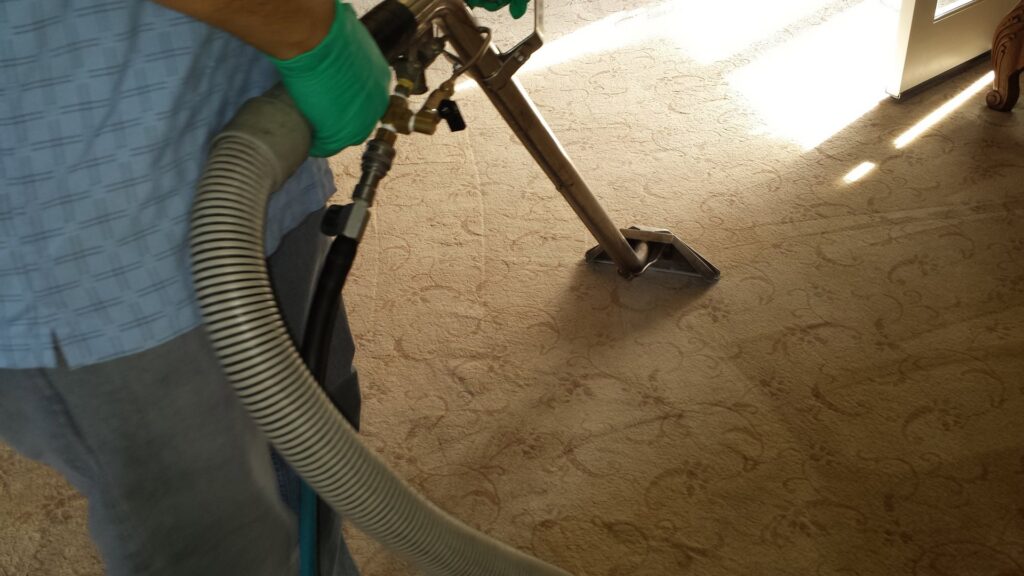 A professional performing deep carpet cleaning with a wand for Harper's Cleaning Services in Anaheim, CA.