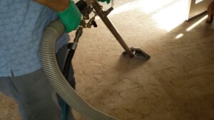 A professional performing deep carpet cleaning with a wand for Harper's Cleaning Services in Anaheim, CA.