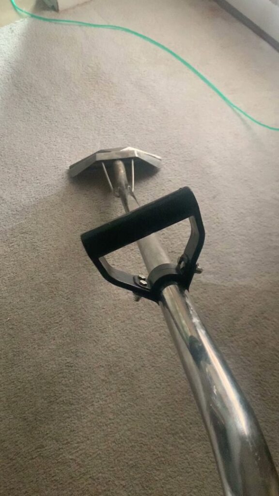 Deep carpet cleaning service being performed with a professional wand on a light grey carpet by Superior Carpet Cleaning in Greenville, SC.