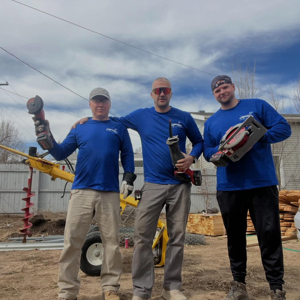 Denfence Team contractors holding power tools with fencing materials in Colorado Springs, CO