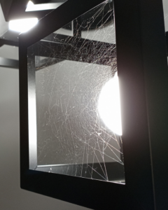 A dense spider web covering a light fixture, indicating a spider pest problem for Pine State Pest Solutions in Auburn, ME.