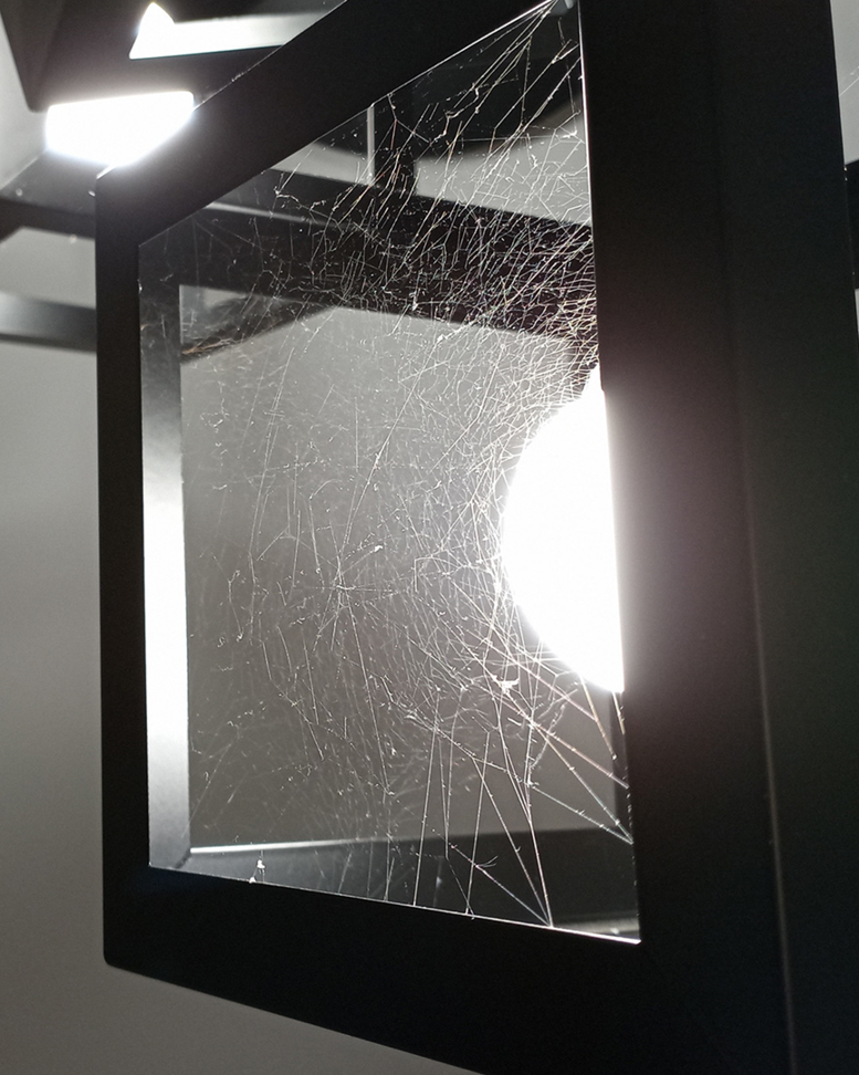 A dense spider web covering a light fixture, indicating a spider pest problem for Pine State Pest Solutions in Auburn, ME.