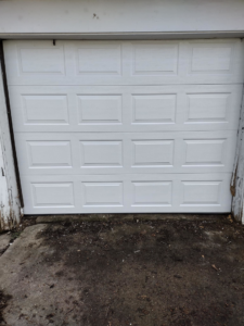 A white residential garage door installed on a detached garage by Codiwayne Construction & Door in South Bend, IN.