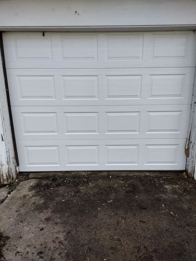 A white residential garage door installed on a detached garage by Codiwayne Construction & Door in South Bend, IN.