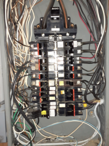 A detailed view of an electrical breaker panel with wiring, showcasing work by Benoit Electrical Services in Litchfield, NH.