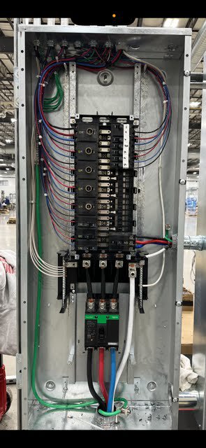 A detailed view of neatly wired circuit breakers inside an electrical panel by Cummings Electric in South Burlington, VT.