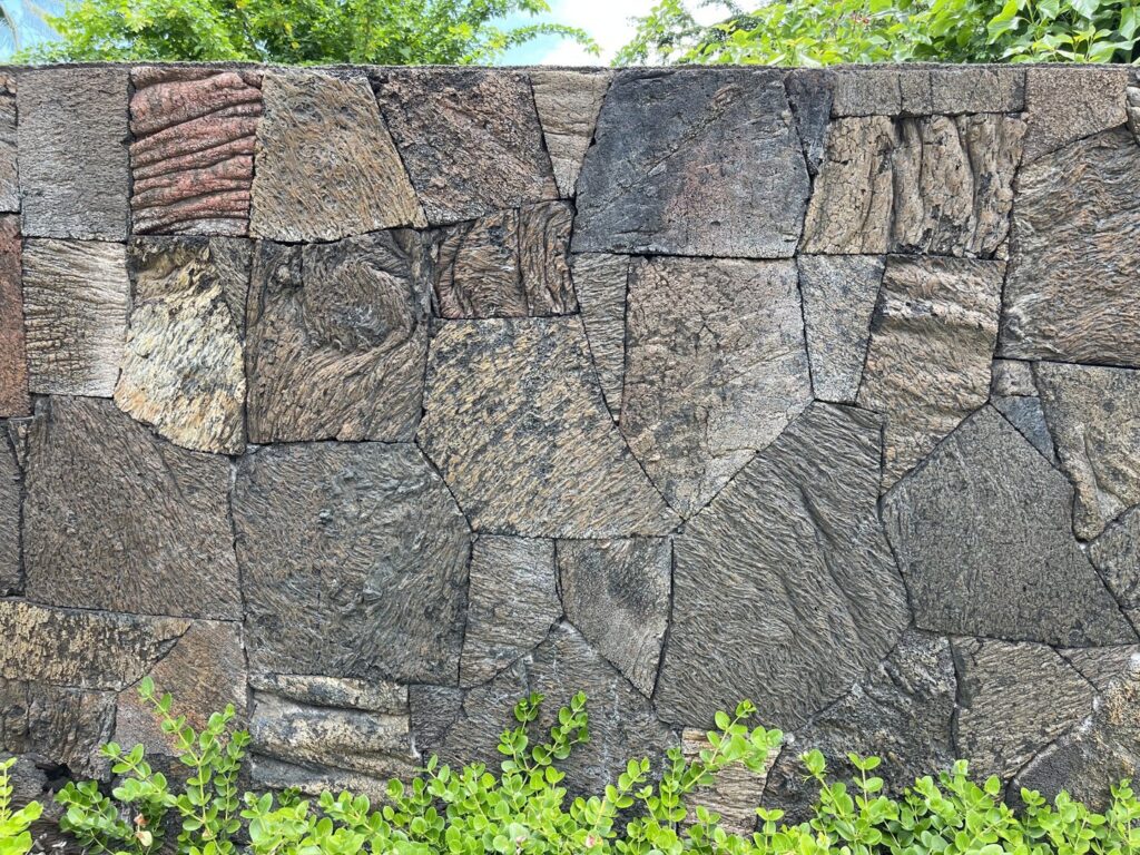 A close-up view of a detailed lava rockwall texture installed by Fence, Gates and Rockwalls in Kailua-Kona, HI