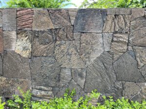 A close-up view of a detailed lava rockwall texture installed by Fence, Gates and Rockwalls in Kailua-Kona, HI