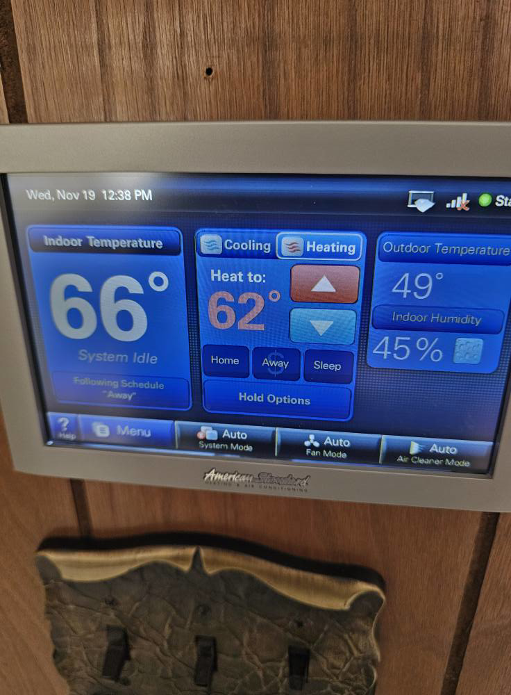 A digital thermostat display showing heating and cooling settings by Comforttechs in Lincoln, NE.