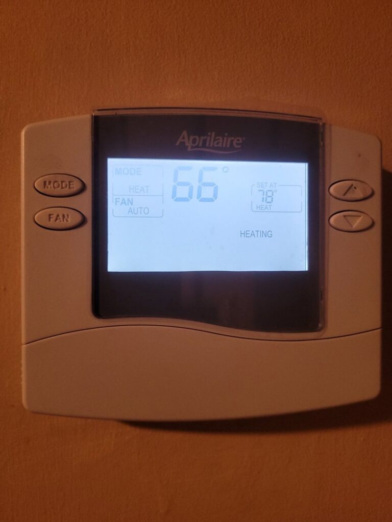 A digital thermostat displaying '66' degrees and 'HEATING' for an HVAC system by Eveready Service Experts in Henrico, VA.