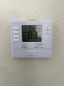 A digital thermostat installed on a wall, showing temperature settings by Honest AC Experts in Las Vegas, NV