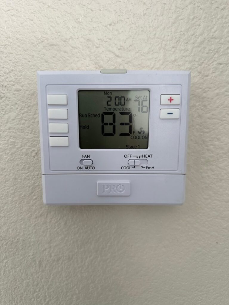 A digital thermostat installed on a wall, showing temperature settings by Honest AC Experts in Las Vegas, NV