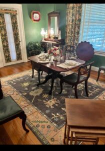 A stylish area rug enhancing a dining room setting, a service provided by Woven Treasures, Inc in Mobile, AL.