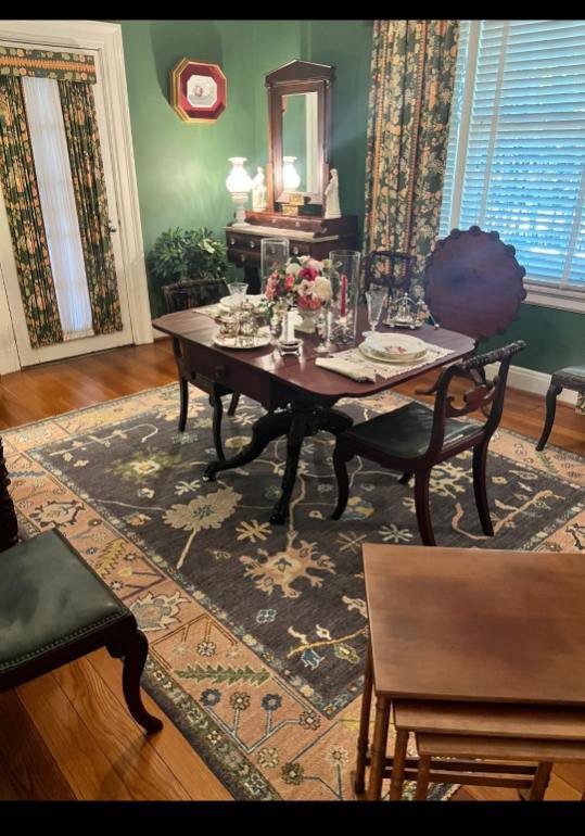 A stylish area rug enhancing a dining room setting, a service provided by Woven Treasures, Inc in Mobile, AL.
