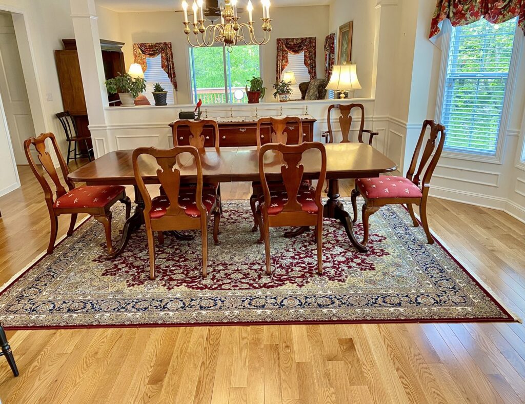 A classic patterned area rug perfectly placed under a dining table by Kaoud Rugs in West Hartford, CT.
