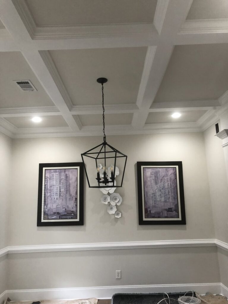 A dining room featuring a modern chandelier and recessed lights installed by McCall Enterprises in Atlanta, GA.