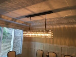 A luxurious rectangular crystal chandelier installed over a dining table by TGR Electric LLC in Carmel, IN.