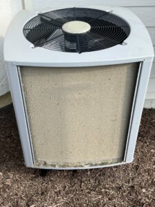 A dirty outdoor AC unit coil covered in debris, indicating a need for maintenance by 4-BIS Solutions HVAC and Home Maintenance in Columbia, MO.