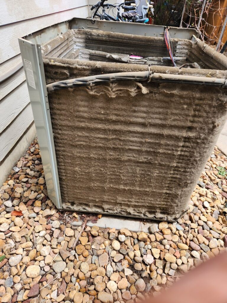 Dirty AC condenser coils exposed for cleaning by EPCTL Heating and Cooling in Byers, CO.